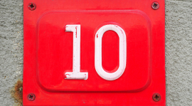 Un panneau métallique rouge avec le chiffre dix en blanc.