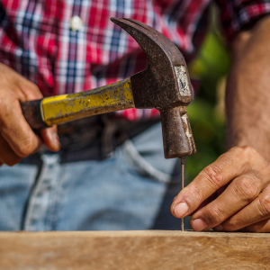 Man hammering a nail into wood