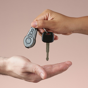 Un adulte passe la clé d’un véhicule dans la main d’une autre personne.