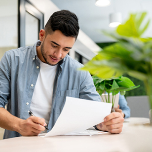 Man working at the office and reviewing and signing paperwork. 