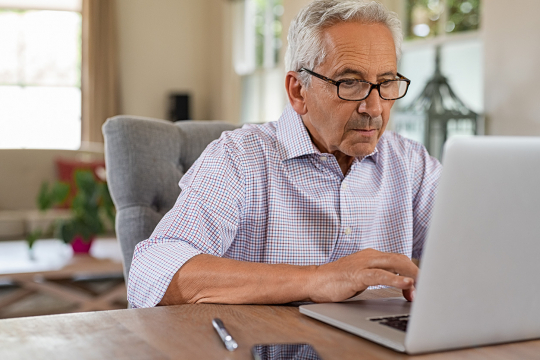 Un homme âgé utilisant un ordinateur.