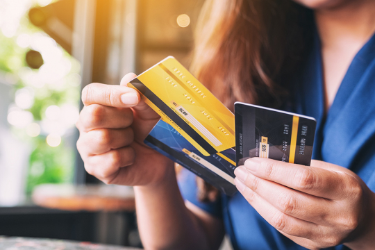 Plan rapproché d’une femme choisissant une carte de crédit