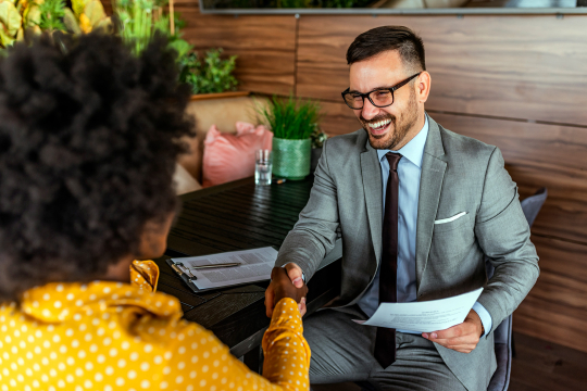 Smiling man shaking women's hand