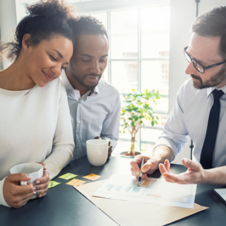 Happy couple talking with their financial adviser 