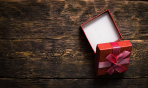 Small, open gift box on a wooden surface.