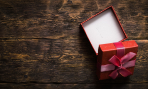 Une petite boîte cadeau ouverte sur une surface en bois.